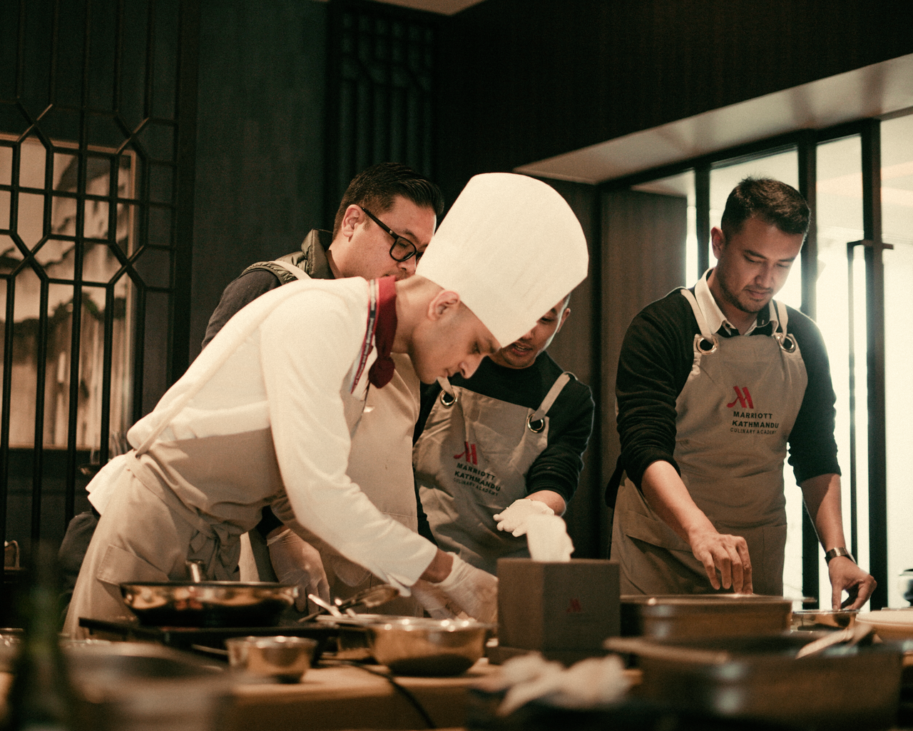 journey-01 Team of chefs working together in a modern restaurant kitchen, preparing gourmet dishes with precision and skill.